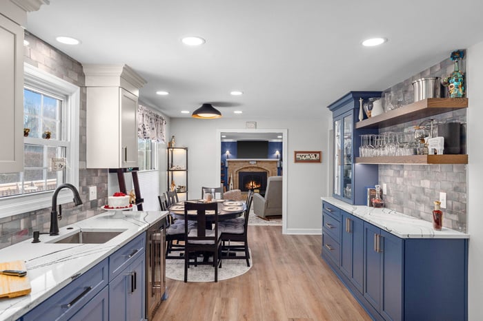 Newly renovated kitchen and open floor plan living room featuring vibrant, colorful cabinetry, a spacious bar area with open shelving, and a modern, inviting design.