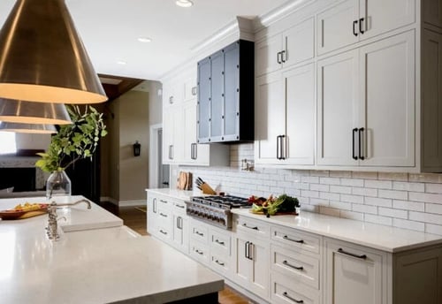 A luxurious kitchen with fully custom cabinets, featuring intricate wood detailing and gold hardware.