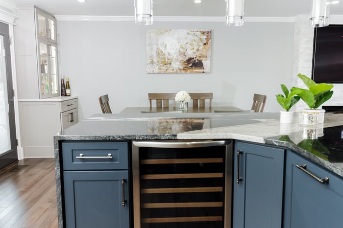 Kitchen countertop with a clean, modern design overlooking an open dining area featuring a stylish table setup with chairs, creating a seamless flow between spaces.